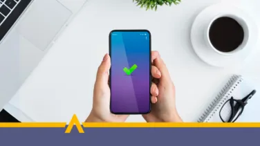 Osoba trzymająca telefon z zielonym znakiem potwierdzenia